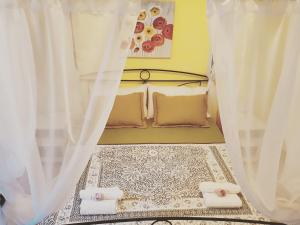 um pequeno quarto com uma cama com cortinas brancas em Lumia e Zagara em Taormina