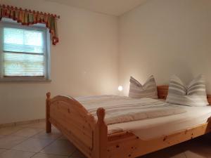 a bedroom with a wooden bed and a window at Ehrentaler Ferienhaus GbR in Schmalkalden