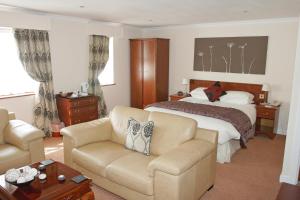 a hotel room with a bed and a couch at Beaufort Park Hotel in Mold