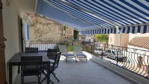 a patio with a table and chairs on a balcony at Anatole - T3 - Moderne - Climatisé - 1er étage - Très grande terrasse - Vue magnifique et dégagée in Saint-Mandrier-sur-Mer