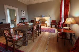 une salle à manger avec une table, des chaises et une cheminée dans l'établissement Kinghorn Town Hall, à Kinghorn