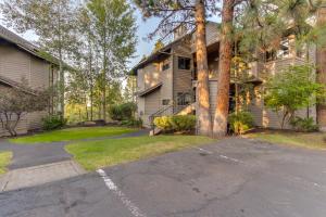 a house with a tree and a driveway at Seclusion in Century West in Bend