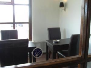 a dining room with a table and chairs and a mirror at Badhotel Zeecroft in Wijk aan Zee