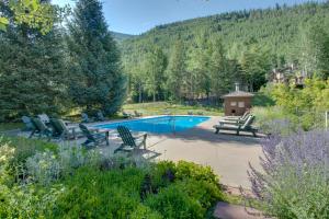 a pool with chairs and a gazebo in a garden at Cozy Mountain Getaway in Vail
