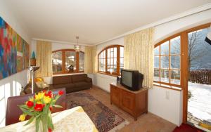 a living room with a couch and a tv at Apparthotel Restaurant Steiners in Eben im Pongau