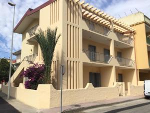 een gebouw met een palmboom ervoor bij Casa Marylu con giardino in Marina di Schiavonea