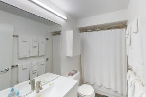 ein weißes Bad mit einem Waschbecken und einer Dusche in der Unterkunft Brighton #116 in Girdwood