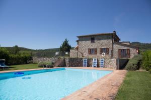 a swimming pool in front of a stone house at Villa Podere S.Antonio in Orvieto
