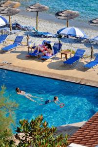 a group of people swimming in a swimming pool at a beach at Adrina Beach Hotel in Panormos Skopelos