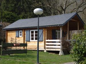 una cabaña de madera con un poste de luz delante en Dirbach Plage Parc, en Dirbach