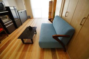 a living room with a blue couch and a table at Kyoto-Gion Tourist House in Kyoto