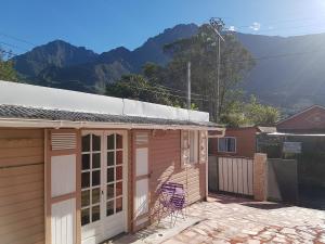 a small house with a table and a chair outside at Le Moutardier 2 in Cilaos