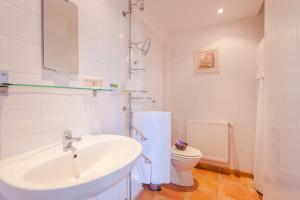 a white bathroom with a sink and a toilet at Normandy Inn in Montbray