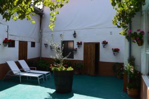 - un patio avec des chaises et des fleurs dans un bâtiment dans l'établissement Casa Rural Los Lláganos, à Villaturiel