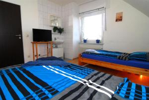 a bedroom with two beds and a television and a window at Monteurzimmer Krings Baptistastr 2a in Eschweiler