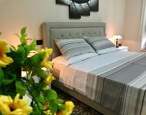 uma cama num quarto com flores amarelas no primeiro plano em B&B Villa Roma em Piazza Armerina