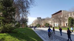 a group of people walking and riding bikes down a sidewalk at Apartment on Nazarbayeva 77 in Almaty