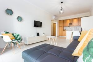 uma sala de estar com um sofá azul e uma cozinha em Kali Apartment - with Pool em Portimão