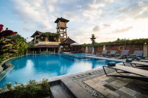 a large swimming pool with a tower in the background at Bali Ayu Hotel & Villas in Seminyak