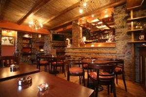 a restaurant with wooden tables and chairs and a bar at Exohiko in Palaios Agios Athanasios