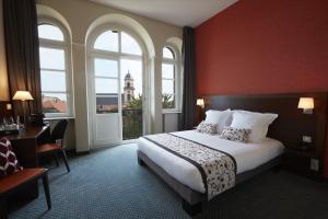 Rúm í herbergi á Hôtel Val-Vignes Colmar Haut-Koenigsbourg, The Originals Relais