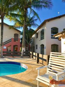 Villa con piscina y banco en Pousada Icaraí en Ilha Comprida