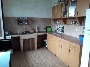 a kitchen with wooden cabinets and a counter top at kobuleti bagrationi 40 in Kobuleti