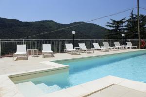 a pool with lounge chairs and a bunch ofitures at Albergo Elisa in Comano