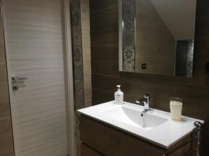 La salle de bains est pourvue d'un lavabo blanc et d'un miroir. dans l'établissement La Casa Nel barocco, à Naro