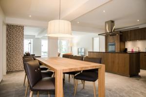 a dining room and kitchen with a wooden table and chairs at Apartment JungfrauCenter Schynige Platte - GriwaRent AG in Interlaken