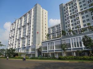 a large white building with motorcycles parked in front of it at Scientia Residences Gading Serpong by Taslim in Serpong