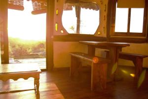 a room with a table and a bench and windows at Tao Sierras De Aigua in Aiguá