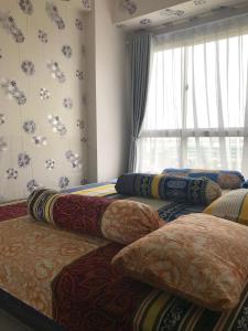 - un ensemble d'oreillers sur un lit dans l'établissement Scientia Residences Gading Serpong by Taslim Property, à Serpong