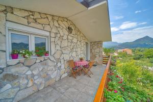 une maison en pierre avec une table et des chaises sur une terrasse dans l'établissement Villa Semeder, à Virpazar