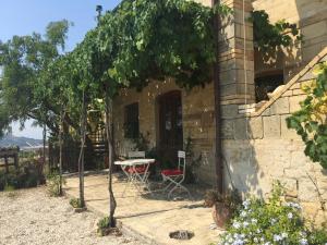 um pátio com uma mesa, uma mesa e uma cadeira em Agriturismo Montedago em Ancona