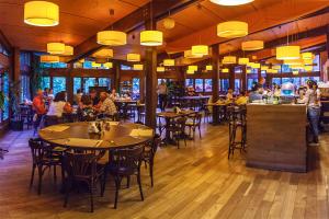 a restaurant with tables and people sitting at tables at Hotel Piatra Soimului in Sinaia