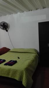 a bedroom with a green bed with a hat on it at Aparta estudio en Ibagué in Ibagué