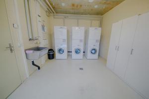ein Badezimmer mit vier Waschmaschinen und einem Waschbecken in der Unterkunft HITrental Allmend Standard Studios in Luzern