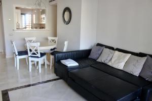 salon z czarną kanapą i stołem w obiekcie Roda Golf & Beach Resort, Murcia w mieście Roda