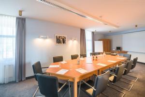 a conference room with a large wooden table and chairs at ACHAT Hotel Lohr am Main in Lohr am Main