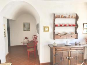 サンタ・テレーザ・ガッルーラにあるCasa Giacriのダイニングルーム(テーブル、赤い椅子付)