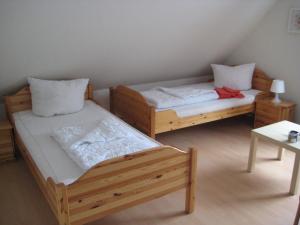 ブルハーフェにあるFerienwohnungen Aikaのテーブル付きの客室内の木製ベッド2台