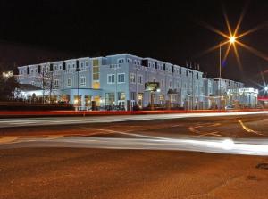 a large white building on a city street at night at Clanree Hotel & Leisure Centre in Letterkenny