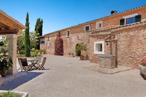 een binnenplaats van een gebouw met tafels en stoelen bij Torrent Fals in Santa Maria del Camí