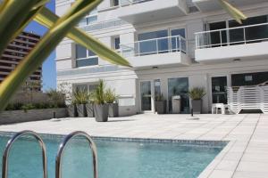 a house with a swimming pool in front of a house at Punta del Este Lux Tower in Punta del Este