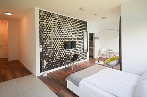 a bedroom with a wall with a tv and a bed at Eco Smart Apartments Erlangen in Erlangen