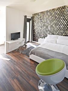 a bedroom with a bed and a green chair at Eco Smart Apartments Erlangen in Erlangen