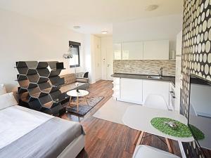 a bedroom and living room with a bed and a kitchen at Eco Smart Apartments Erlangen in Erlangen