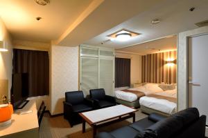 a hotel room with a bed and a living room at Hotel Johzenji in Sendai