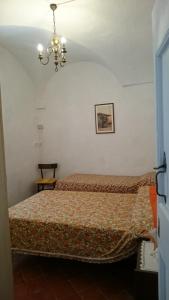 een slaapkamer met een bed en een kroonluchter bij Risorgimento Apartment in Cipressa